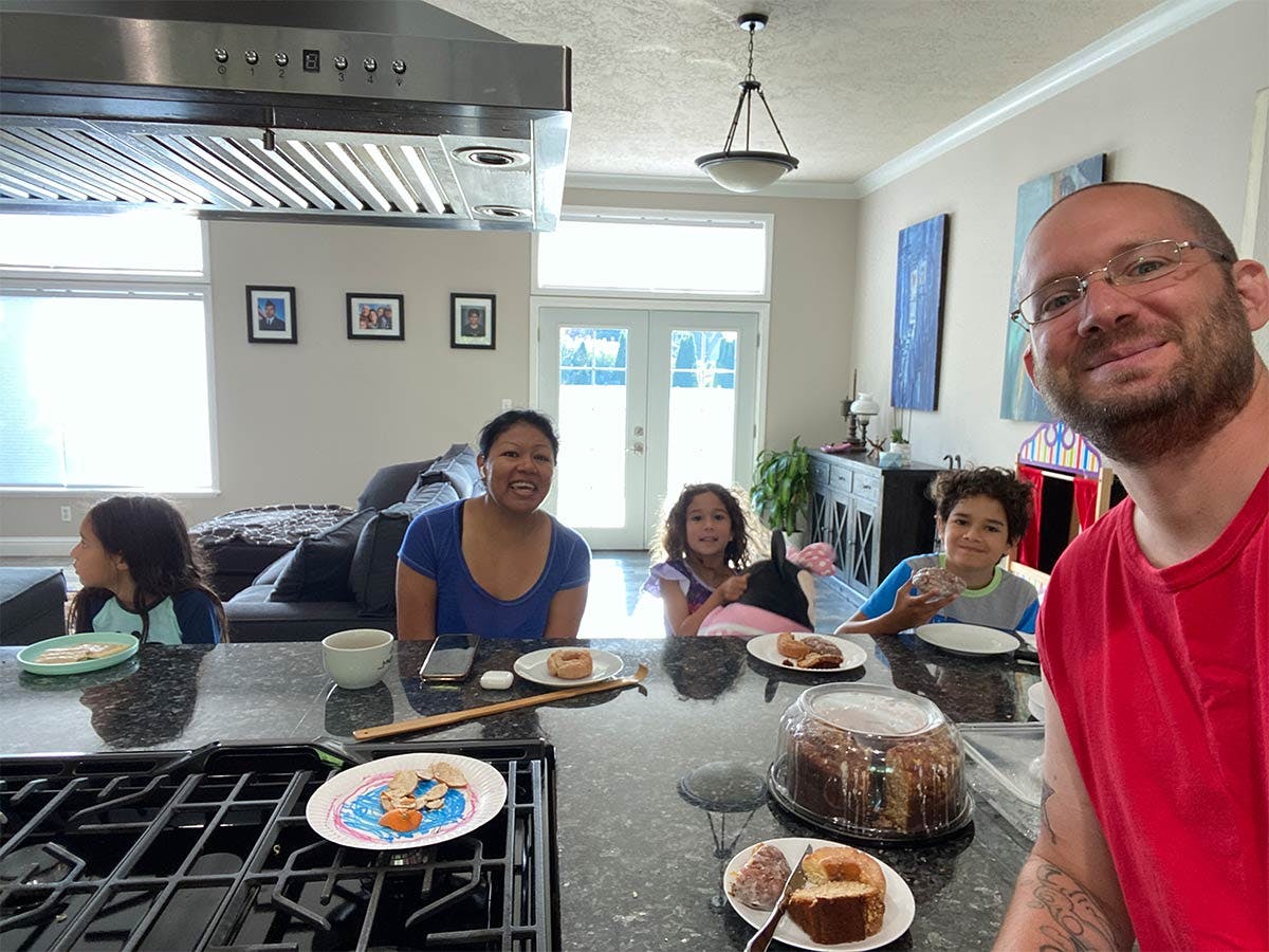 Mike eating breakfast with his wife Yohana and their children.